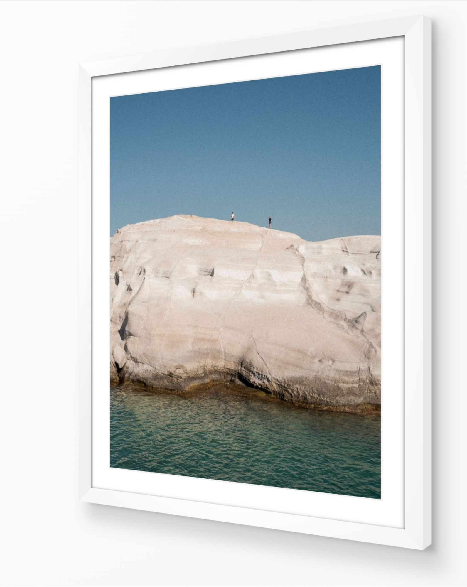 Sarakiniko II – Milos fine-art print in white frame by Sam Smeaton — textured white stone landscape and crystal-clear water from the Cyclades