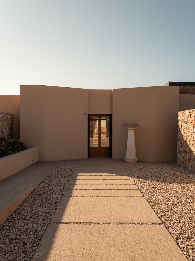 Contemporary villa entrance with geometric design and soft natural hues.
