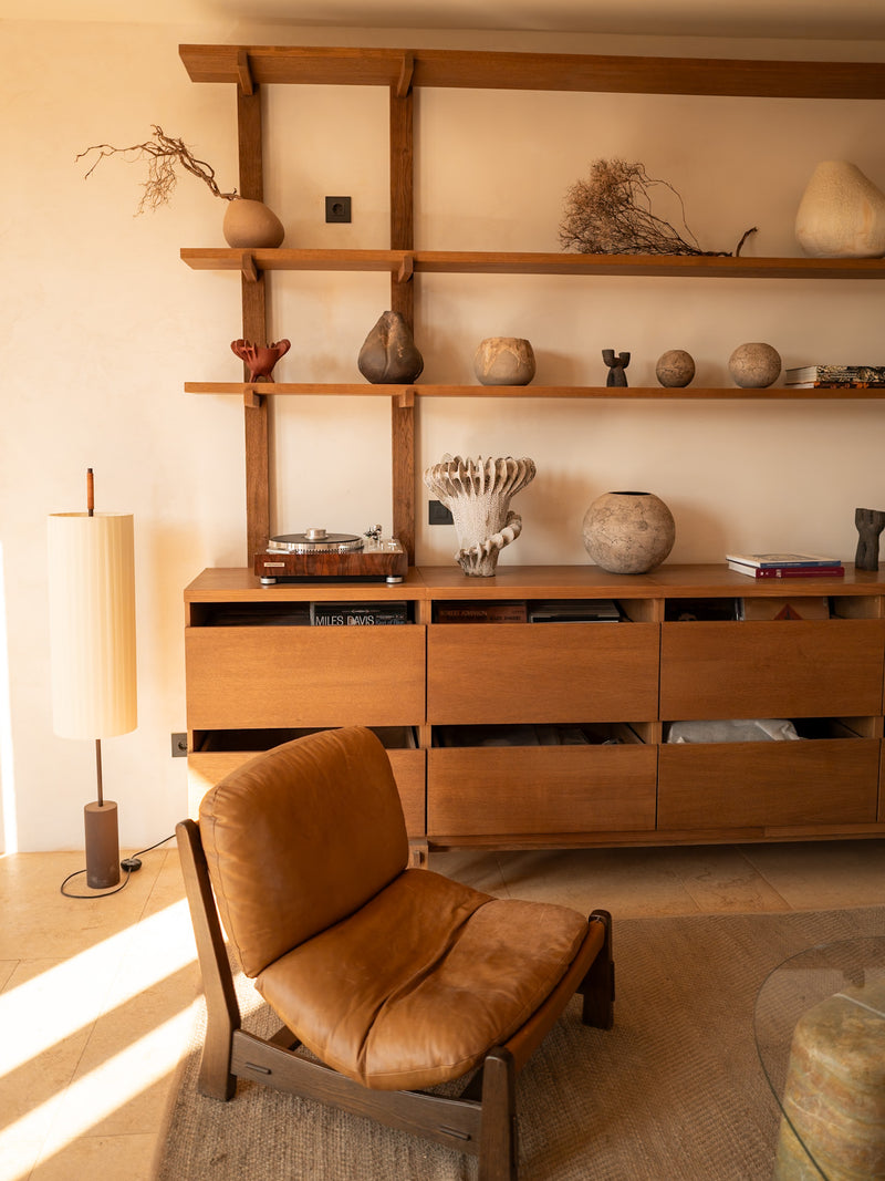 Editorial interior photography with wooden shelves, ceramics, and textured natural light.