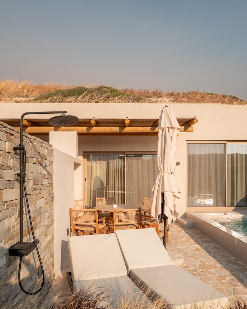 Greek villa terrace with sunbeds and turquoise pool under morning light.