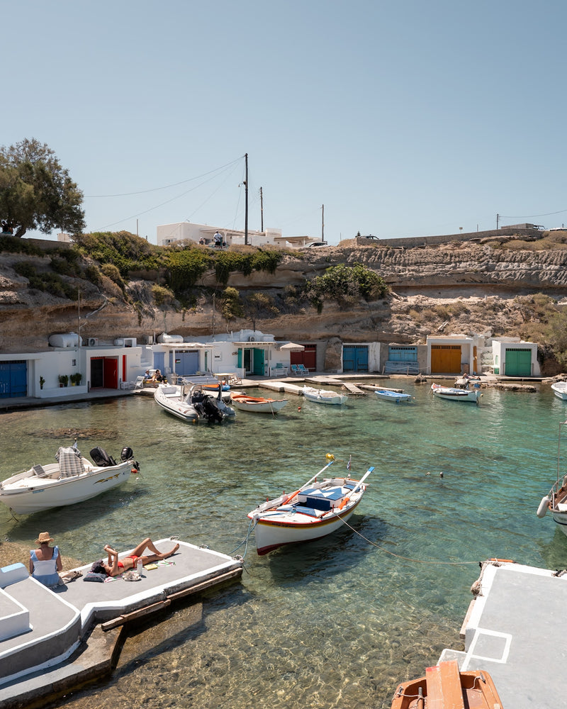 Mandrakia II – Milos fine-art print by Sam Smeaton — Greek island fishing cove with turquoise water, whitewashed boathouses, and moored boats