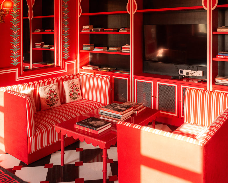 Red-and-white reading room at Villa Palladio Jaipur with striped sofas, vintage books, and warm afternoon light — photographed by Sam Smeaton.