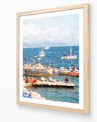 Santa Margherita fine-art print by Sam Smeaton — Mediterranean seascape with red lifeguard boat and cobalt umbrellas, framed in natural oak for warm coastal texture.