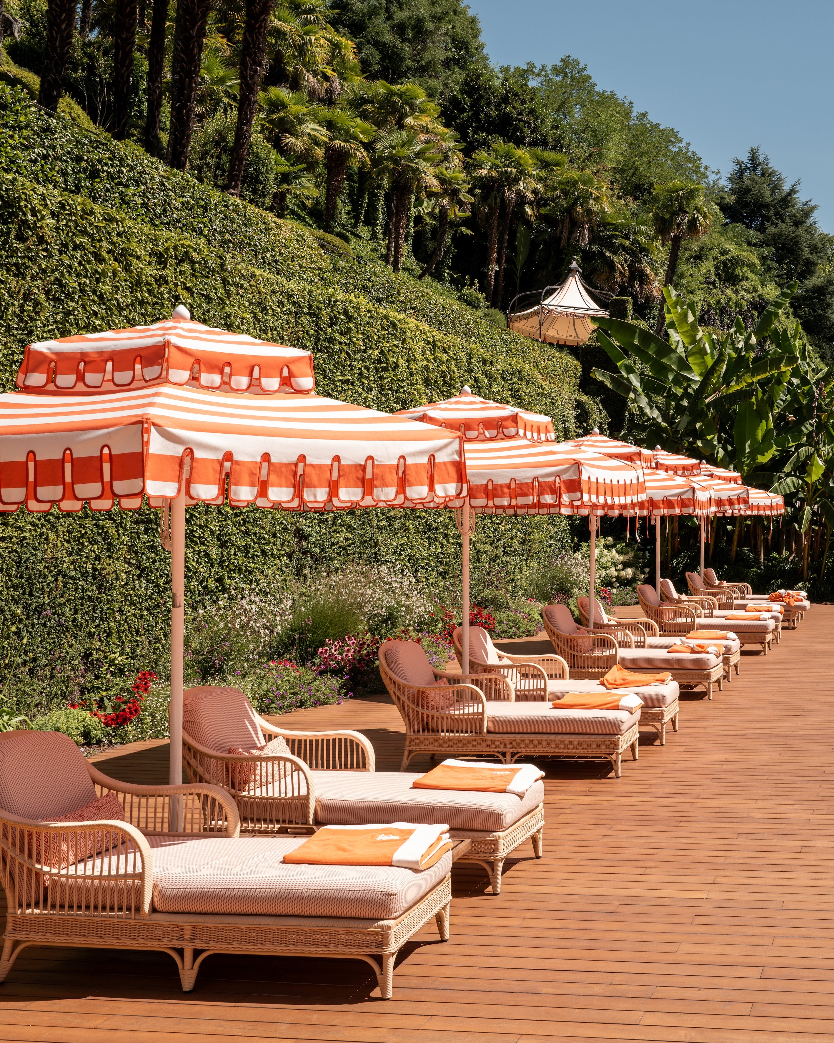 Fine-art photography print of Sun Loungers of Tremezzo by Sam Smeaton — Lake Como’s orange-and-white umbrellas and rattan lounges captured in warm sunlight, printed on premium matte fine-art paper, 