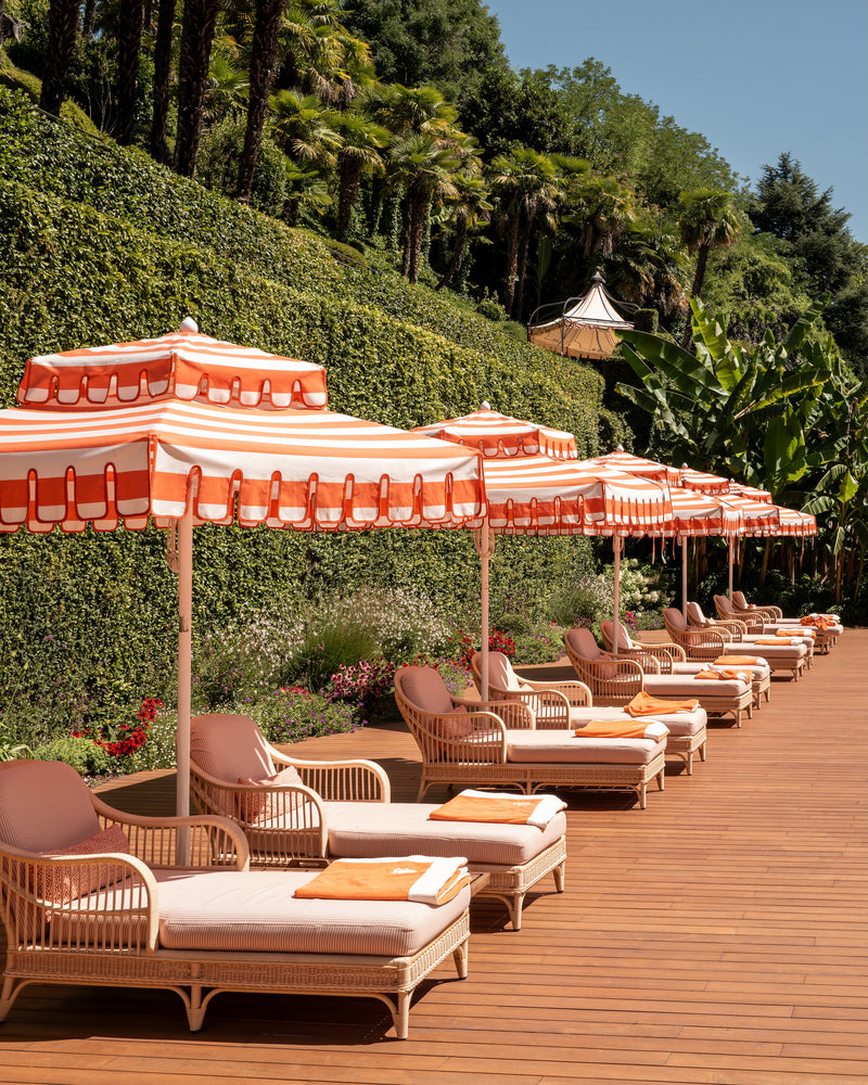 Fine-art photography print of Sun Loungers of Tremezzo by Sam Smeaton — Lake Como’s orange-and-white umbrellas and rattan lounges captured in warm sunlight, printed on premium matte fine-art paper, 